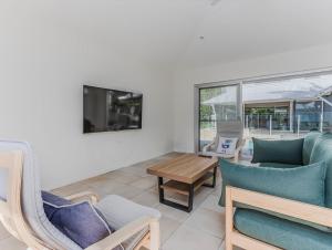 a living room with a couch and a table at Macadamia Ocean Escape in Pottsville