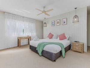 a bedroom with a bed with a green blanket on it at Macadamia Ocean Escape in Pottsville +50 photos