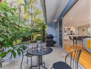 an open living room with tables and chairs and a grill at Macadamia Ocean Escape in Pottsville