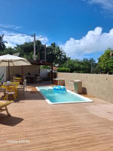 a swimming pool with a table and an umbrella at Antunes Beach Flats Paradise in Maragogi