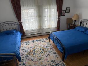 a bedroom with two beds and a rug at Classical American House 3 in Brooklyn