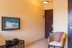 a living room with a tv and a chair at Beach Break Suites Sayulita in Sayulita