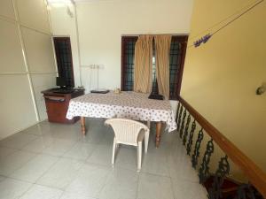 a table and chair in a room with a window at D Cunhas Riviera in Cochin