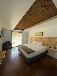 a bedroom with a large bed and a desk at Ávita Lodge in Quesada