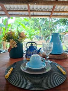 a table with a plate and a teapot on a table at Portal Das Fadas - Hospedagem in Cavalcante