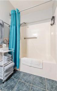 a bathroom with a shower with a blue shower curtain at Bourbon Roost in Saint Francis +22 photos