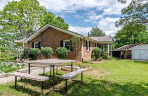 a brick house with a picnic table in the yard at Bourbon Roost in Saint Francis