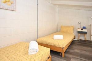 a small room with two beds and a table at Beachfront 1BR Loft. Surf-Café-Unwind in Marcoola