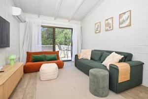 a living room with a couch and a chair at Beachfront 1BR Loft. Surf-Café-Unwind in Marcoola