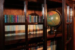 a book shelf with a globe on top of it at Jamarauja in Biar