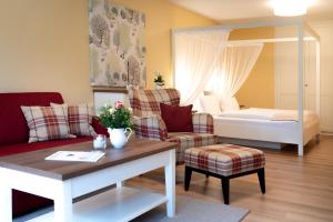 a living room with a couch and a bed at Hotel Landhaus Ellerbrock in Böhl