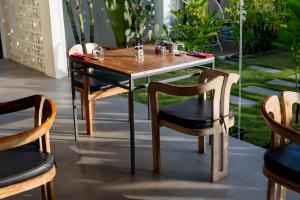 a wooden table and chairs on a patio at Amazing Lombok Resort in Selong Belanak