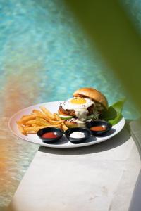a plate of food with a sandwich and french fries at Amazing Lombok Resort in Selong Belanak