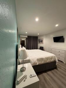 a hotel room with a bed and a table with a lamp at Stardust Hotel in Miami Beach