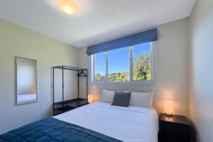 a bedroom with a bed and a large window at Selwyn Heights in Akaroa