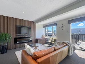 a living room with a couch and a television at Selwyn Heights in Akaroa