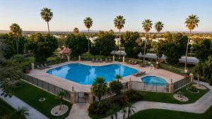 an aerial view of a resort pool with palm trees at Yuma Inn & Suites in Yuma