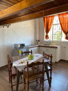a kitchen with a table and chairs in a room at Cabañas San Carlos - Puembo Centro in Puembo