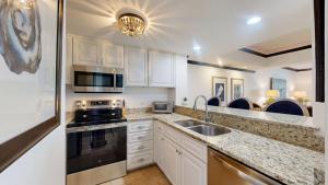 a kitchen with white cabinets and a sink and a stove at 240 Captains Quarters in Hilton Head Island