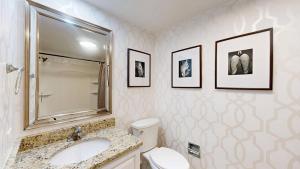 a bathroom with a sink and a toilet and framed pictures at 240 Captains Quarters in Hilton Head Island +20 photos