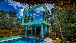 a house with a swimming pool and a blue building at Kaan Serenity Sanctuary in Coba