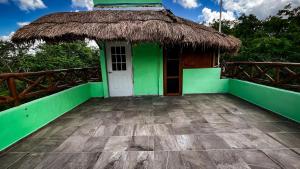 a green house with a straw roof at Kaan Serenity Sanctuary in Coba