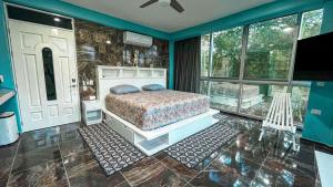 a bedroom with a bed in a room with windows at Kaan Serenity Sanctuary in Coba