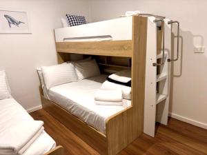 a bunk bed in a room with white towels at 180 Degrees - Amazing Bay Views in St Helens