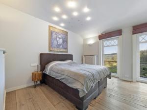a bedroom with a large bed and two windows at Luxury Country House with Pool in Manhay +32 photos