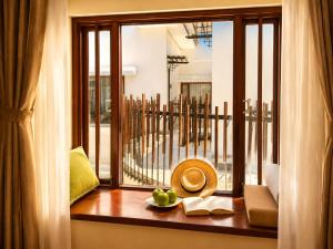 a window with a bowl of fruit on a table at Happy Life Memories Hoi An Hotel & Spa in Hoi An +82 photos
