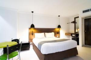 a bedroom with a bed and a desk and a table at Calypso Beach Hotel in San Andrés +42 photos