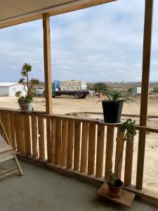 a porch with potted plants and a view of a field at Cabañas CR guanaqueros in Coquimbo