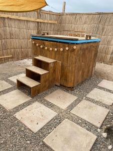a wooden bath tub with stairs next to a fence at Cabañas CR guanaqueros in Coquimbo +2 photos