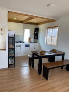 a living room with a table and a kitchen at Cabañas CR guanaqueros in Coquimbo