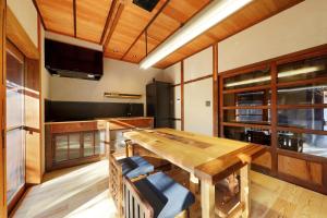 a dining room with a wooden table and a tv at YASUYA-yasuya- in Yasugi