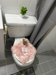 a bathroom with a toilet with a pink furry seat at Ally home 14 08 in Ban Bang Phang