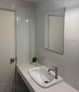 a white bathroom with a sink and a mirror at Ally home 14 08 in Ban Bang Phang +1 photo