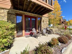 a patio with chairs and a table in front of a building at Antlers Gulch 106 by SummitCove Lodging in Colorado in Keystone +21 photos