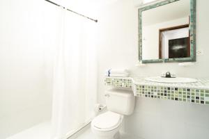a bathroom with a toilet and a sink and a mirror at Calypso Beach Hotel in San Andrés