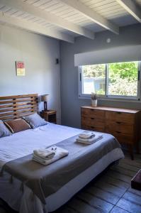 a bedroom with a large bed with towels on it at Entre Las Sierras Tiny House Cabañas in Villa Giardino +31 photos