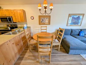 a kitchen and living room with a table and a couch at Expedition Station 8622 by SummitCove Lodging in Colorado in Keystone