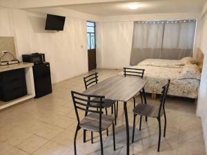 a room with a table and chairs and a bed at Lofts en el Corazon de Coatepec Veracruz in Coatepec