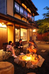 a group of people sitting around a fire at YASUYA-yasuya- in Yasugi