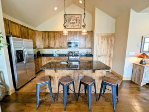 a kitchen with a large island with four stools at Frey Gulch 58 by SummitCove Lodging in Colorado in Keystone