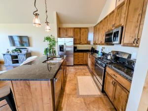 a kitchen with wooden cabinets and a large kitchen island at Frey Gulch 58 by SummitCove Lodging in Colorado in Keystone
