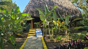 ein Resort mit Strohdach und einem Weg in der Unterkunft Hotel Nueva Alianza in Frontera Corozal
