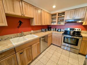 a kitchen with wooden cabinets and a sink at Pines 2129 by SummitCove Lodging in Colorado in Keystone