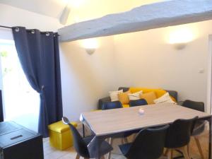 a dining room with a table and a couch at Charmante maison cocooning au cœur du Bourbonnais, animaux acceptés - FR-1-489-68 in Broût-Vernet +5 photos