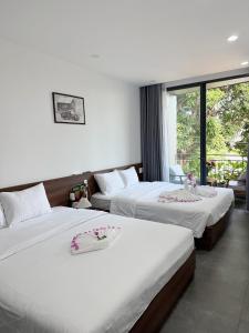 a hotel room with two beds with flowers on them at Khánh Vy Homestay in Thôn Lại Thê