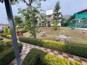 a view of a garden with tables and chairs at Mohdev Resort in Lakhwār